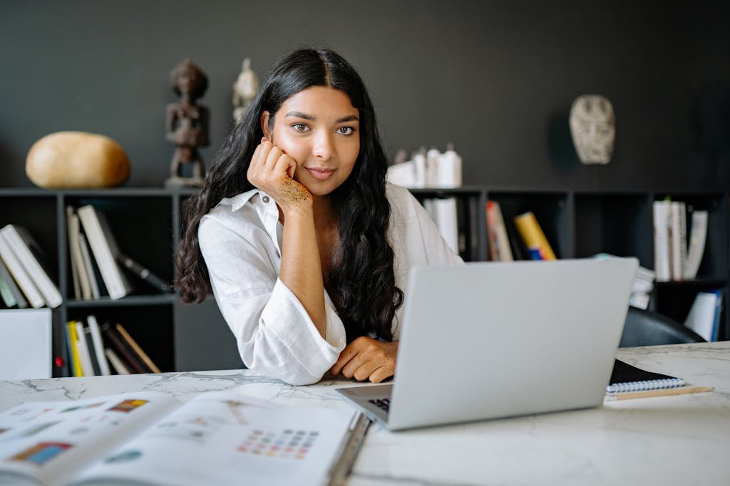 Woman in White Long Sleeve Shirt Using a Laptop